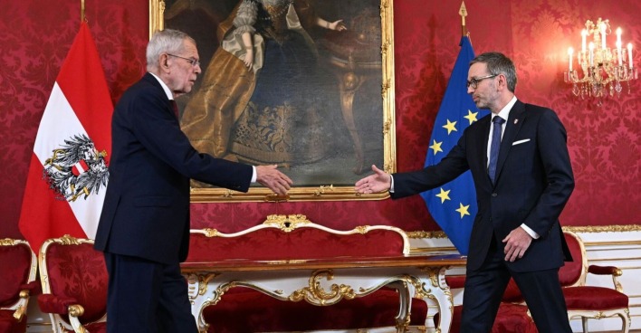 Alexander Van der Bellen und Herbert Kickl gehen in der Hofburg für den ersten Händedruck aufeinander zu, die Hände in der Mitte ausgestreckt