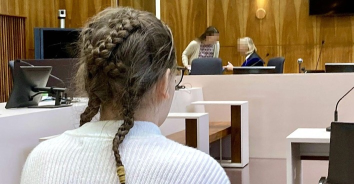 Das 14-jährige Mädchen von hinten vor Gericht.