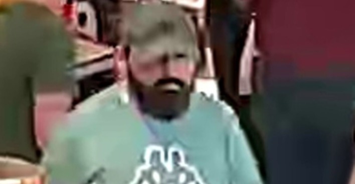 Mann mit dunklem Vollbart, dunkelgrüner Kappe und hellgrünem Shirt