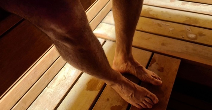 Männerbeine in einer Sauna
