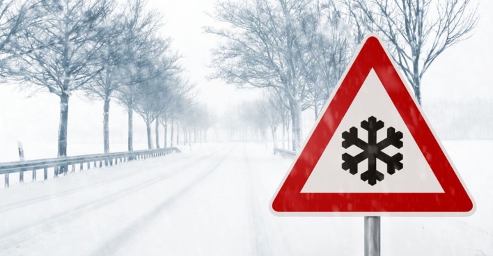 Schneefahrbahn und ein Warnschild