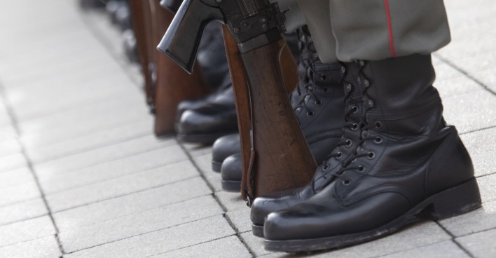 Füße von Soldaten mit Waffen.