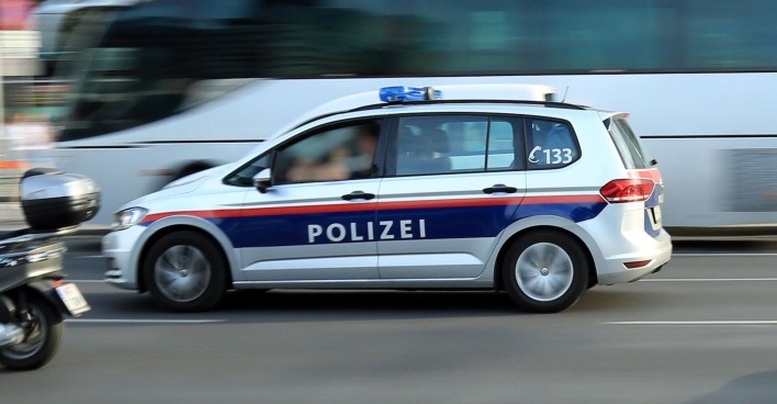Ein Polizeiauto fährt auf einen stark befahrenen Straße zu einem Einsatz.