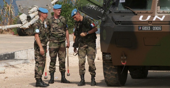 UNO-Blauhelme im libanesischen Camp, eine Gruppe französischer Soldaten neben einem Panzer