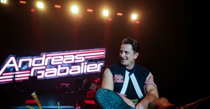 Andreas Gabalier sitzt auf der Bühne