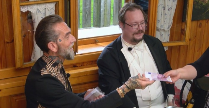 Käse-Millionär Roland und sein Butler verteilen Geldscheine.