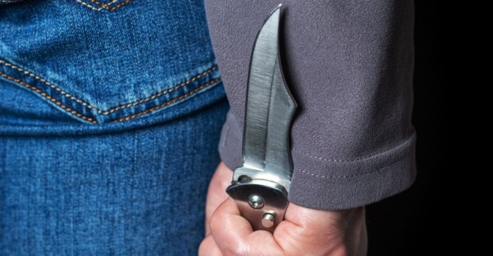 Mann mit Messer hinter dem Rücken versteckt