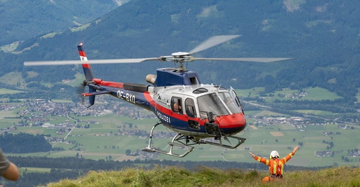 Ein Polizeihubschrauber landet auf einem Berg.