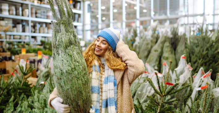 Eine Frau kauft einen Christbaum