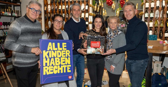 Mehrere Menschen halten ein Plakat und eine Spendenkiste