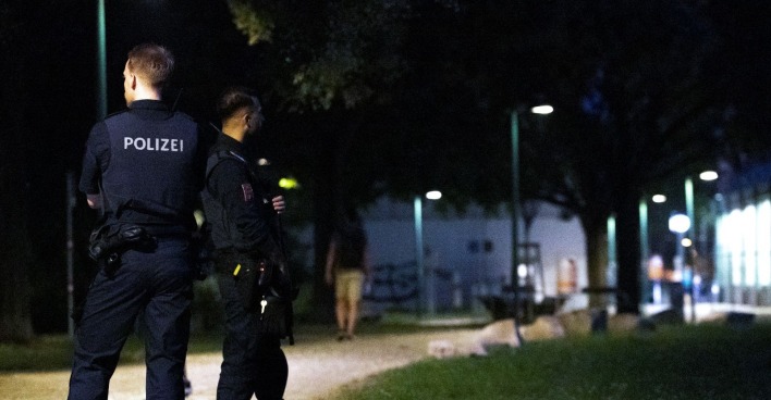 Zwei Polizeibeamten stehen auf einem Gehweg.