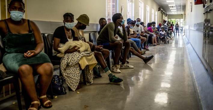 Menschen warten in Afrika im Spital auf einen Arzt.