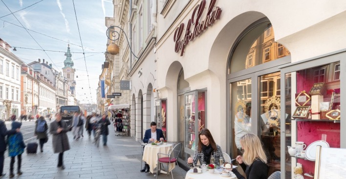 Café Sacher in Graz mit Gästen und belebter Umgebung