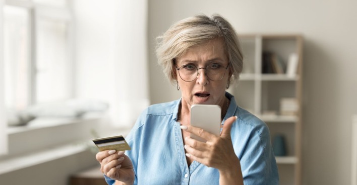 Frau starrt entgeistert auf ihr Smartphone