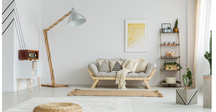 Zimmer mit einer Couch, Teppich und einer Stehlampe