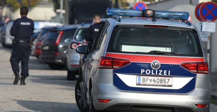 Polizist neben Polizeiwagen