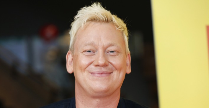 Blonder Mann lacht in die Kamera