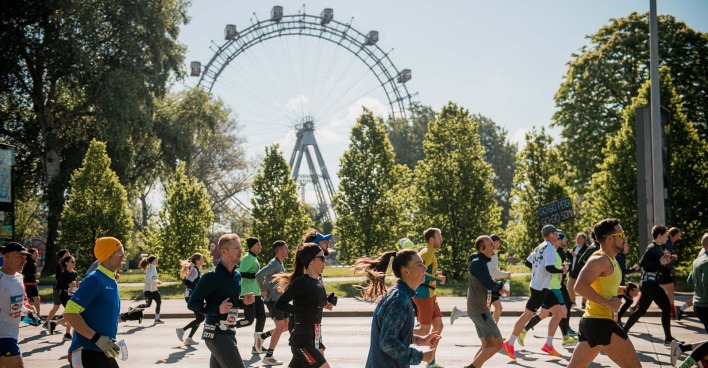 Teilnehmer des Vienna City Marathons mit dem Riesenrad im Hintergrund