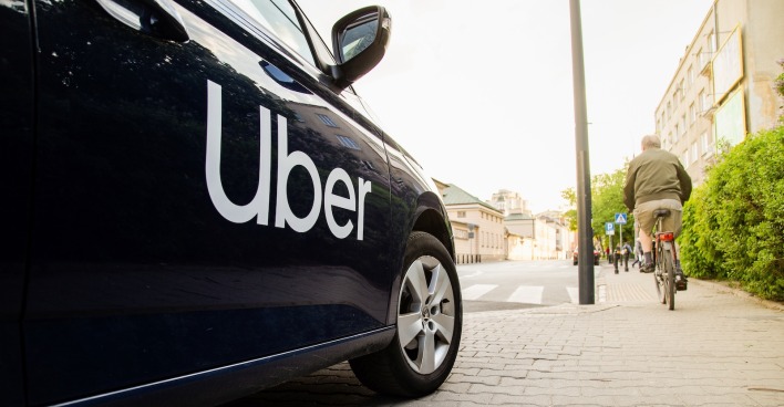 Ein Auto mit der Aufschrift "Uber" hält am Straßenrand.