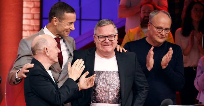Elton lächelt gerührt bei seinem Abschied von „Wer weiß denn sowas?“, flankiert von Bernhard Hoëcker, Kai Pflaume und Oliver Welke.