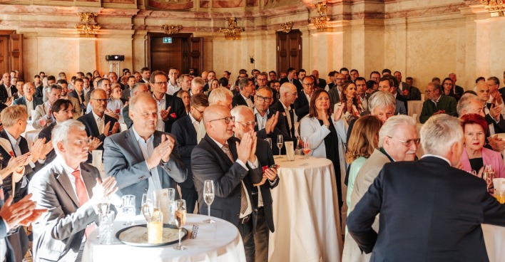 Viele Gästen klatschen an Stehtischen im Palais Niederösterreich