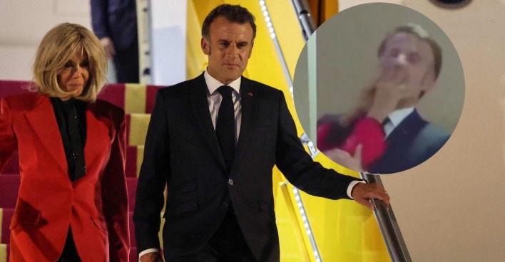 Emmanuel Macron im dunklen Anzug und Brigitte Macron in roter Jacke beim Verlassen eines Flugzeugs in Vietnam. In einem eingeblendeten Kreis ist ein Videoausschnitt zu sehen, in dem Brigitte Macron ihrem Ehemann scheinbar mit der Hand ins Gesicht fasst.