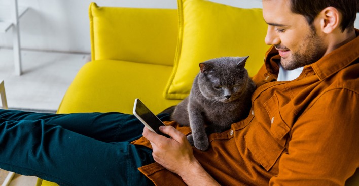 Katze sitzt auf einem Mann | Credit: iStock.com/LightFieldStudios