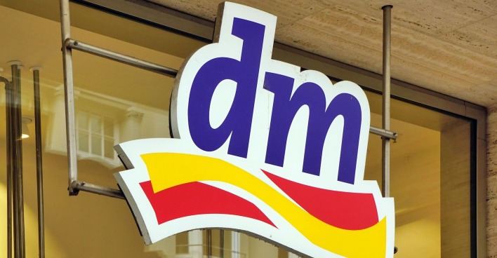 dm-Logo an der Fassade einer Filiale – Drogeriemarktkette ruft Cashewmus mit Himbeere wegen Salmonellengefahr zurück.