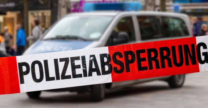 Polizeiauto und Absperrung an einem Tatort.