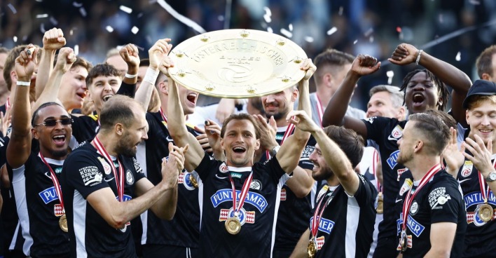 Die Mannschaft von Sk Sturm Graz feiert jubelnd und hält den Meisterteller in die Höhe