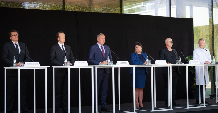 Gruppe von Menschen stehend hinter Podium
