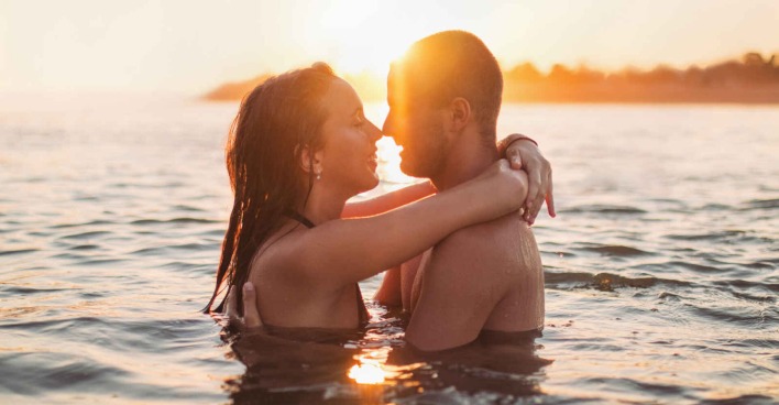 Eine Frau und ein Mann umarmen sich im Wasser