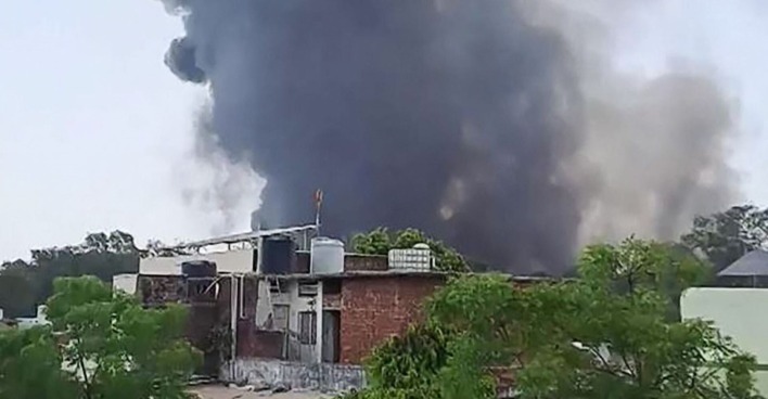 Schwarzer Rauch steigt hinter flachen Wohnhäusern in den Himmel, nachdem ein Flugzeug der Air India nahe dem Flughafen von Ahmedabad abgestürzt ist.