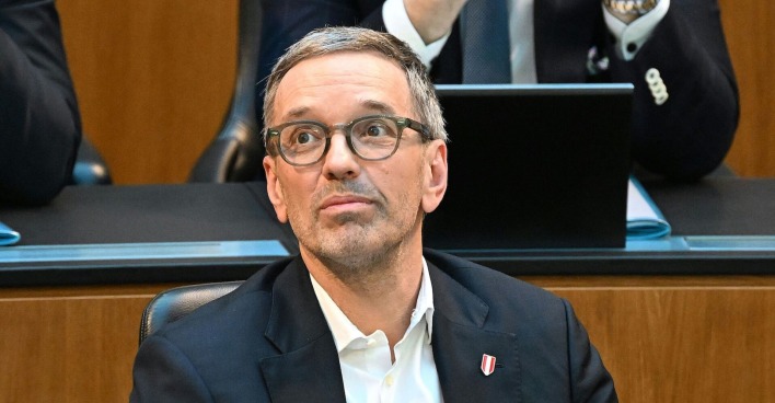 Herbert Kickl im Anzug mit Brille sitzt nachdenklich im Nationalrat.