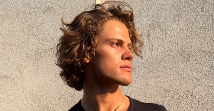 Lucas Braathen schaut zur Seite und steht vor einer Hausmauer