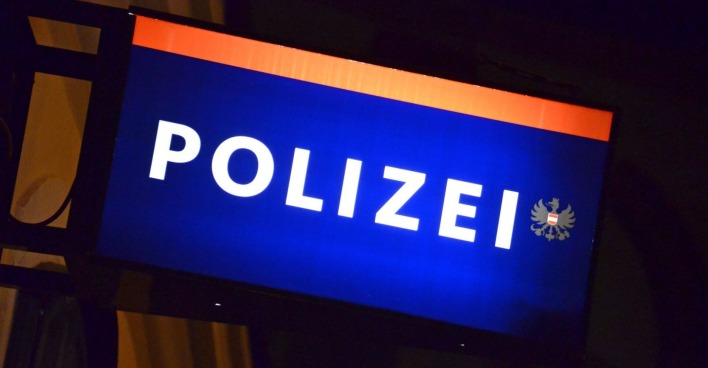 Schild einer Polizeiwache in der Nacht.