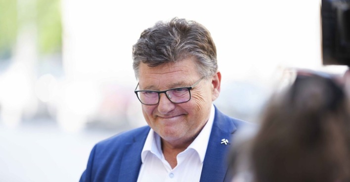 Rainer Wimmer lächelt in einem blauen Sakko mit weißem Hemd und Brille, aufgenommen im Freien bei einem Pressetermin.