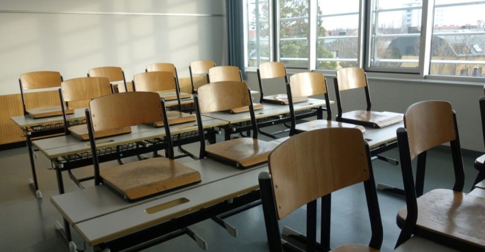 verlassenes Klassenzimmer mit Stühlen, die auf den Tisch gestellt sind