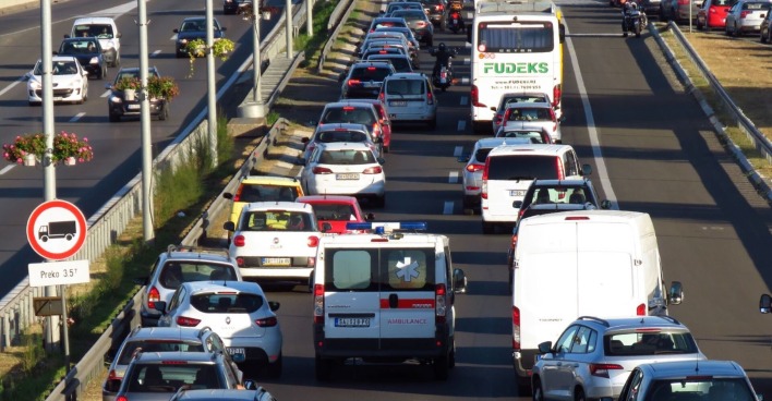 Dichter Verkehr und Stau auf einer mehrspurigen Autobahn in Italien während des Generalstreiks am Feiertag Fronleichnam. Zahlreiche Autos, Busse und ein Rettungswagen stehen still.
