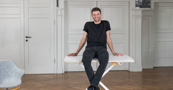 Thomas Müller sitzt auf einem Tisch der Firma poptop