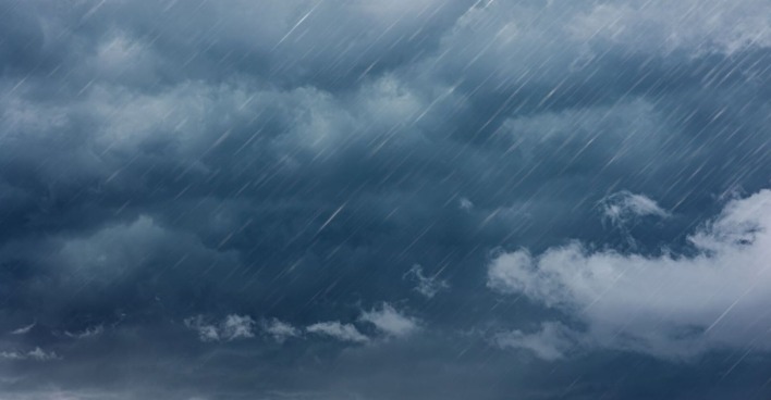 Dunkle, wolkenverhangene Himmelslandschaft mit starkem, schräg einfallendem Regen – Symbolbild für ein schweres Gewitter.