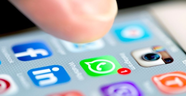 iPhone Display, welches zahlreiche Social Media Apps zeigt, unter andrem WhatsApp