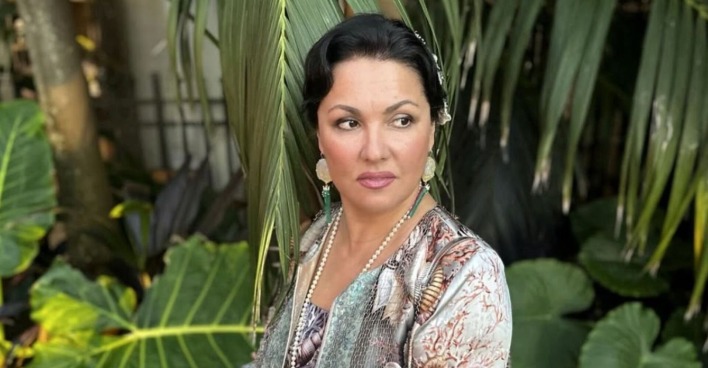 Anna Netrebko mit Pflanzen im Hintergrund