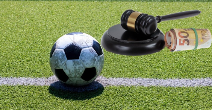Fußball auf einem Feld neben einem Hammer mit einem Gelbündel