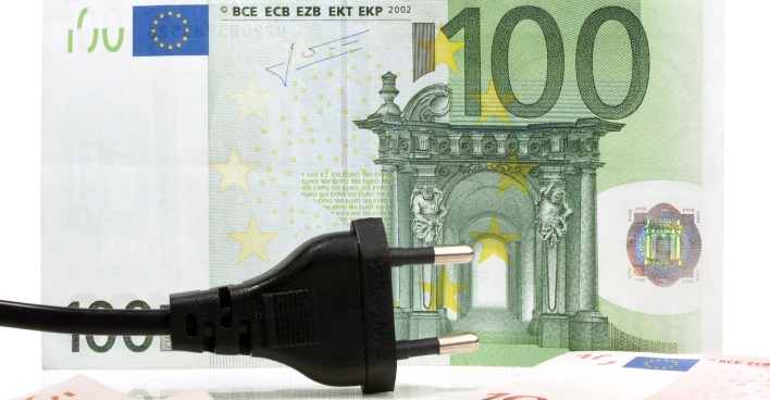 Schwarz glänzender Stromstecker liegt vor einem 100-Euro-Schein – Symbolbild für hohe Energiekosten und mögliche Rückzahlungen.