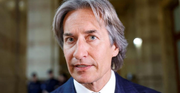 Porträt von Karl-Heinz Grasser im Anzug, aufgenommen in einem Gerichtsgebäude. Der ehemalige österreichische Finanzminister blickt ernst in die Kamera.