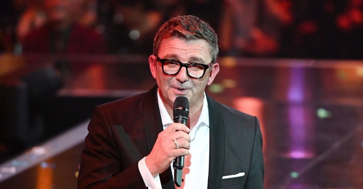 Hans Sigl mit Mikrophon und Brille