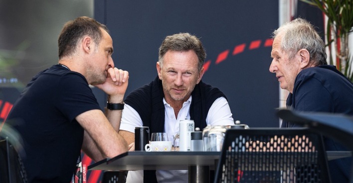 Drei Red-Bull-Verantwortliche sitzen an einem Tisch und führen ein intensives Gespräch, darunter Teamchef Christian Horner und Motorsport-Berater Helmut Marko.