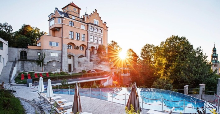Hotel Schloss Mönchstein mit Infinity-Pool im Sonnenuntergang, Blick auf die Stadt Salzburg und den Mönchsberg