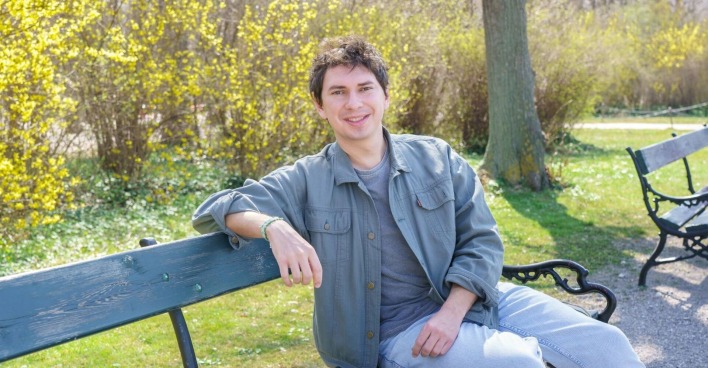 Julian Le Play sitz auf einer Bank